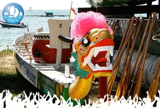 A traditionally decked out craft ready for a dragon boat racing event with a carved and colourful dragon head at the bow